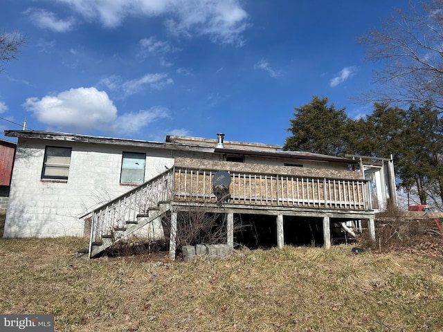 back of house with stairs, concrete block siding, and a deck