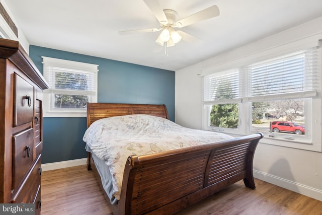 bedroom with light wood finished floors, ceiling fan, and baseboards