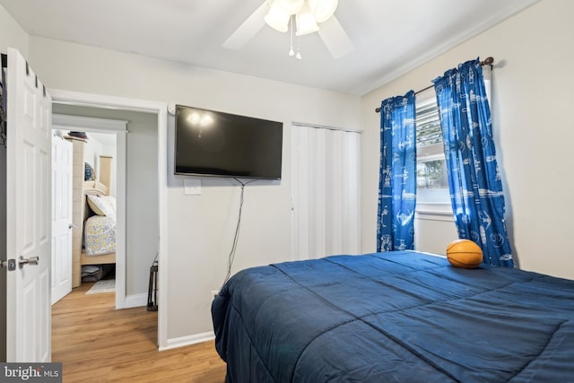 bedroom featuring light wood-style flooring, baseboards, and a ceiling fan