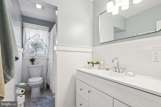 bathroom featuring toilet, curtained shower, tile patterned flooring, and vanity