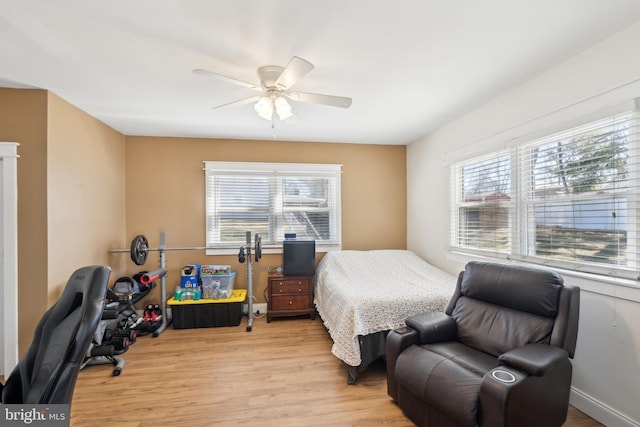 bedroom featuring light wood-style flooring, multiple windows, and a ceiling fan