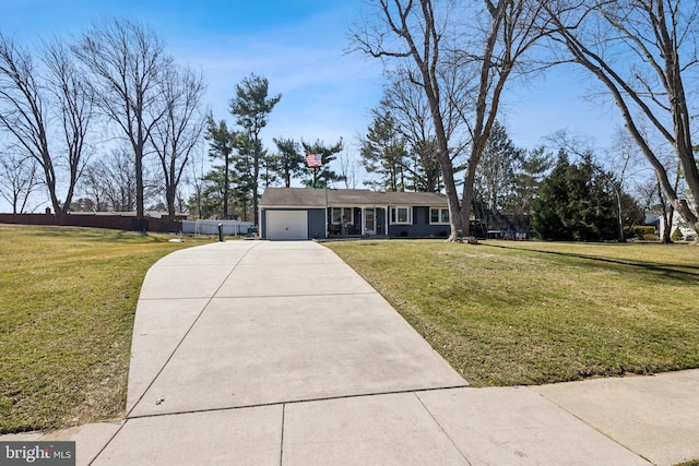 view of front of property featuring an attached garage, driveway, fence, and a front yard