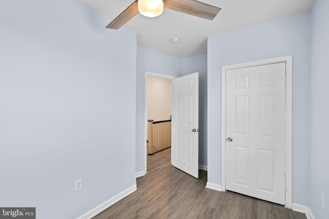 unfurnished bedroom with ceiling fan, baseboards, and wood finished floors