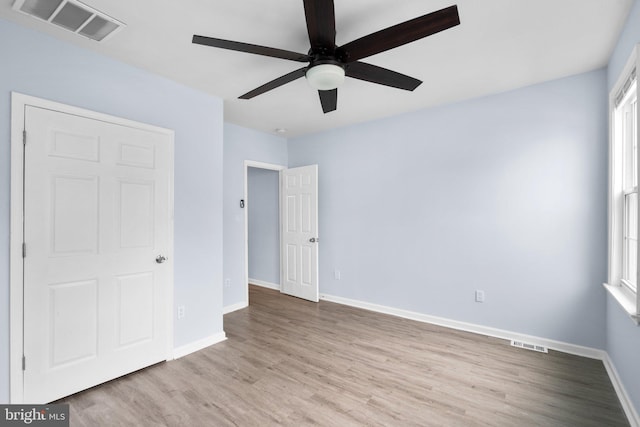 unfurnished bedroom with ceiling fan, wood finished floors, visible vents, and baseboards