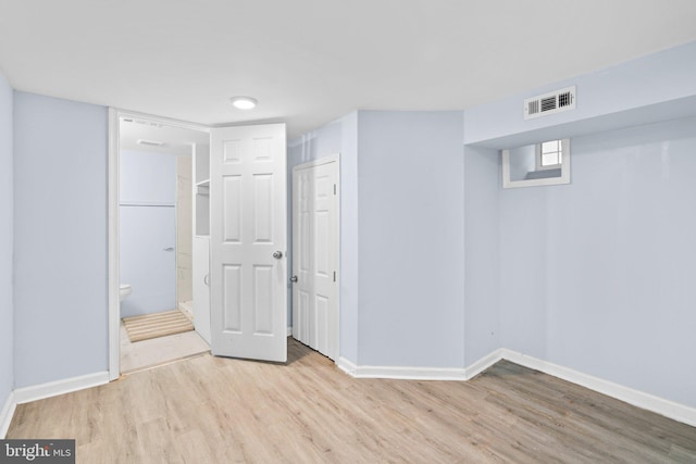 below grade area with wood finished floors, visible vents, and baseboards