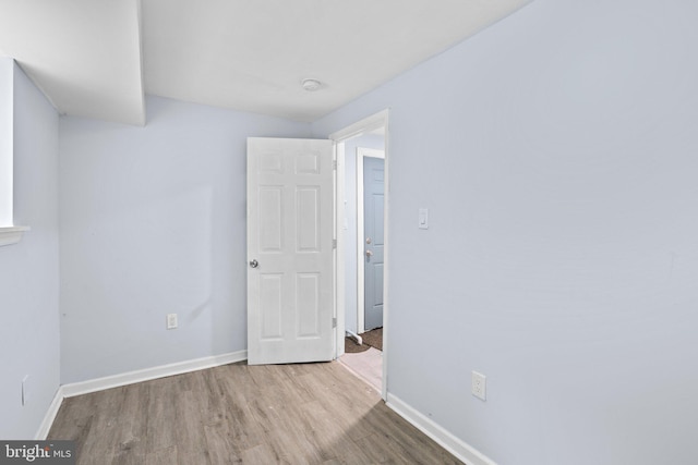 interior space with baseboards and wood finished floors