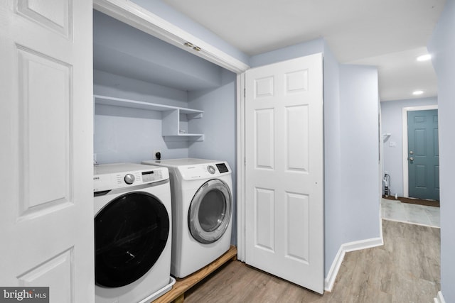 laundry area with washer and dryer, laundry area, baseboards, and light wood finished floors