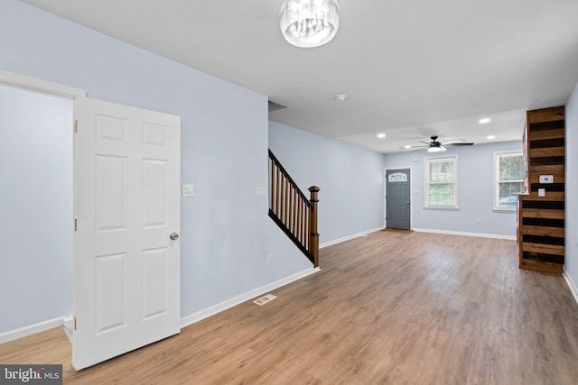 interior space with stairway, light wood-type flooring, visible vents, and baseboards