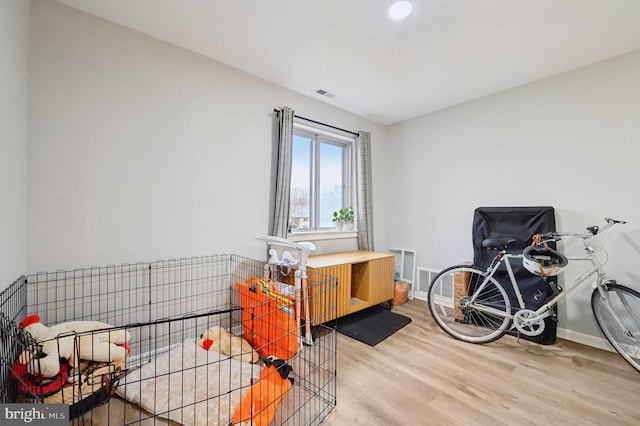 misc room featuring baseboards, visible vents, and wood finished floors