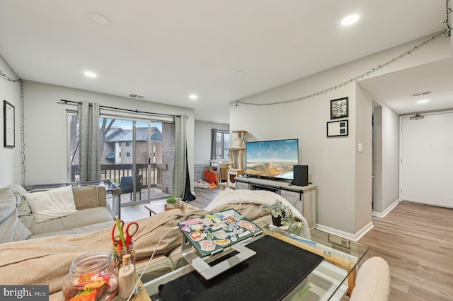 living area with baseboards, recessed lighting, visible vents, and light wood-style floors