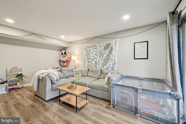 living room featuring recessed lighting, baseboards, and wood finished floors