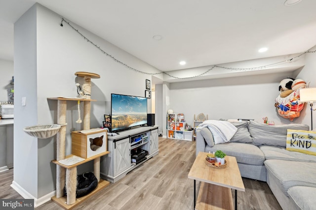 living room with recessed lighting, light wood-style flooring, and baseboards