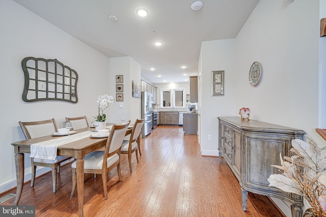 dining space with light wood finished floors, visible vents, recessed lighting, and baseboards