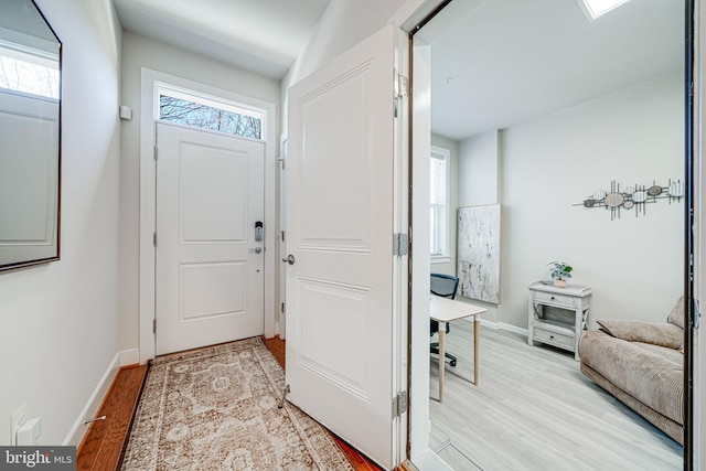 entrance foyer with baseboards and light wood finished floors