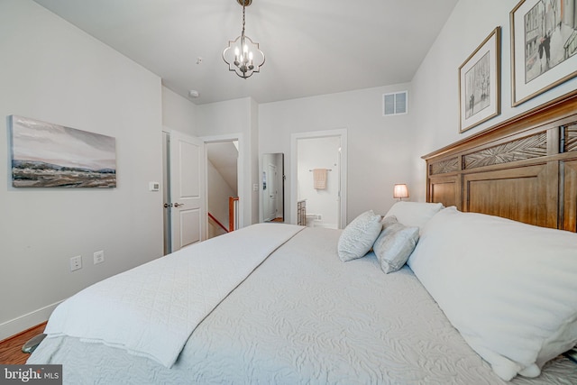 bedroom featuring visible vents, a notable chandelier, wood finished floors, connected bathroom, and baseboards