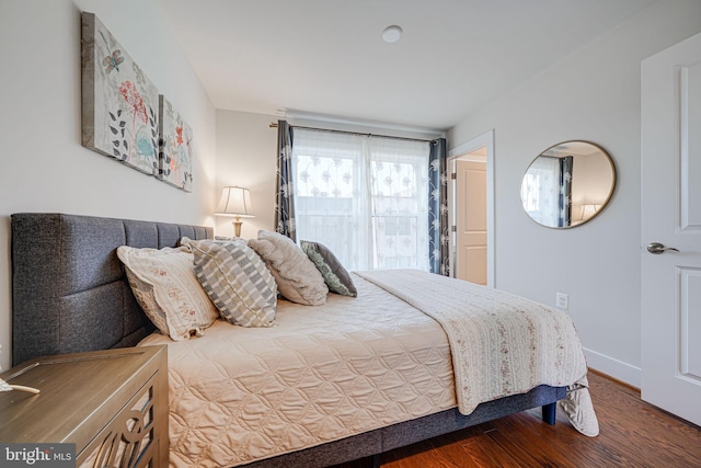 bedroom with wood finished floors and baseboards