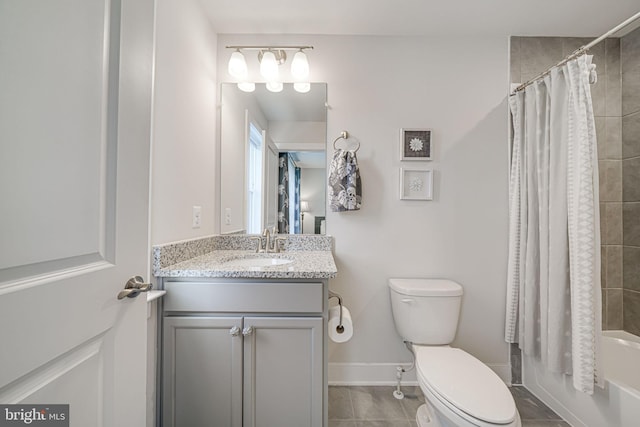 bathroom featuring tile patterned flooring, baseboards, toilet, shower / tub combo with curtain, and vanity