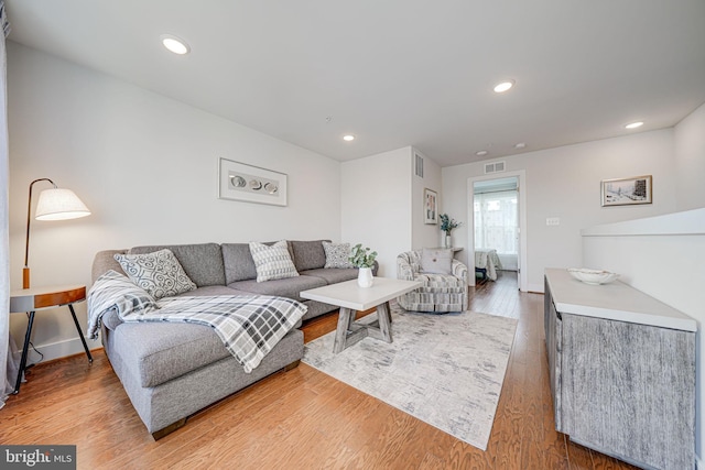 living room featuring recessed lighting, visible vents, and light wood finished floors