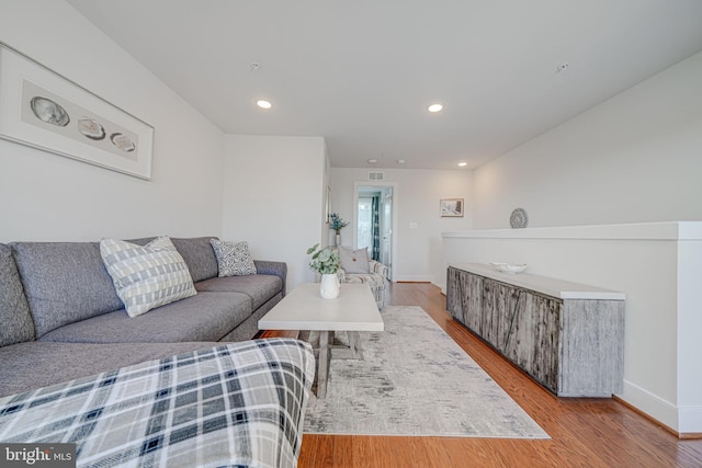 living area featuring recessed lighting, baseboards, and wood finished floors