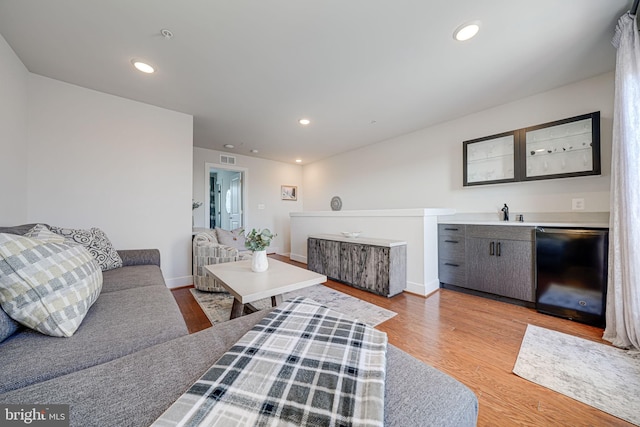 living area featuring visible vents, recessed lighting, light wood-type flooring, and baseboards