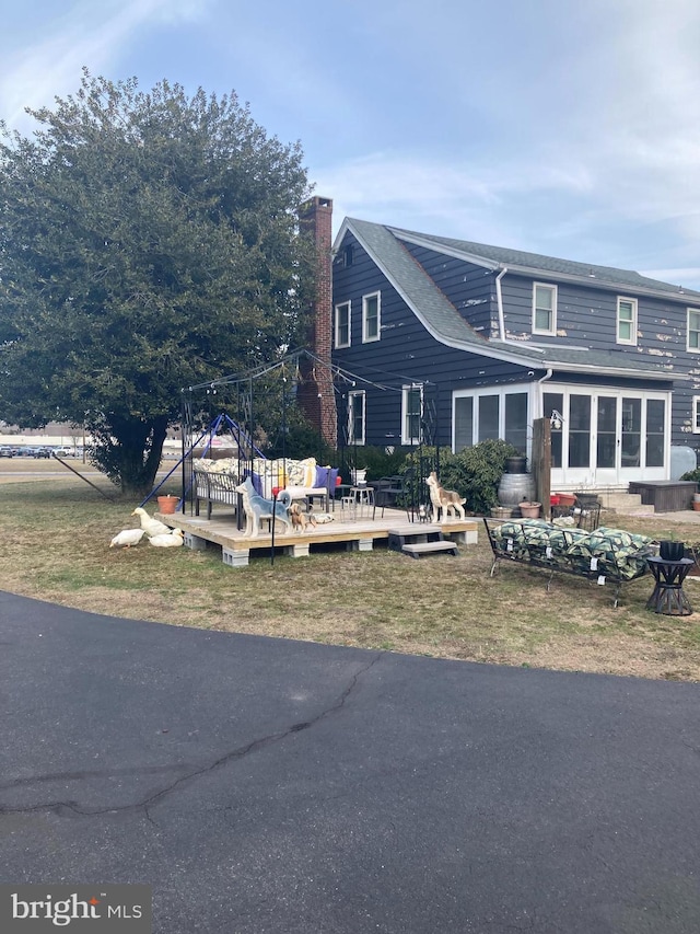 view of front of house with a chimney and a wooden deck