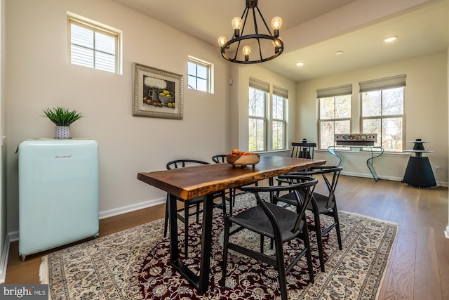 dining room with a chandelier, recessed lighting, baseboards, and wood finished floors