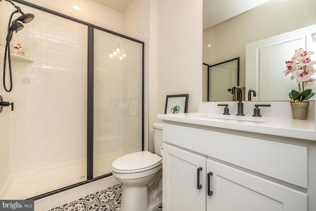 full bathroom featuring a stall shower, vanity, and toilet