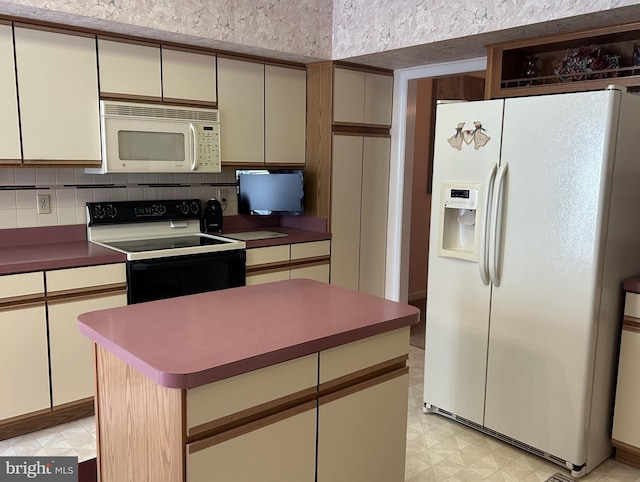 kitchen featuring white appliances, dark countertops, cream cabinetry, light floors, and backsplash