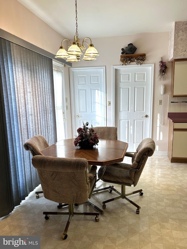 dining area with a chandelier and baseboards