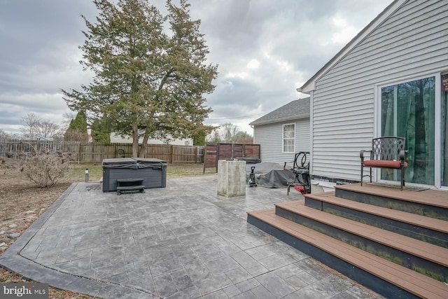 view of patio with a fenced backyard and a hot tub