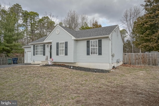 view of front of property with entry steps, a shingled roof, a front yard, and fence