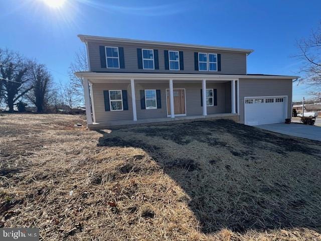 view of front of house featuring a garage, driveway, and a porch