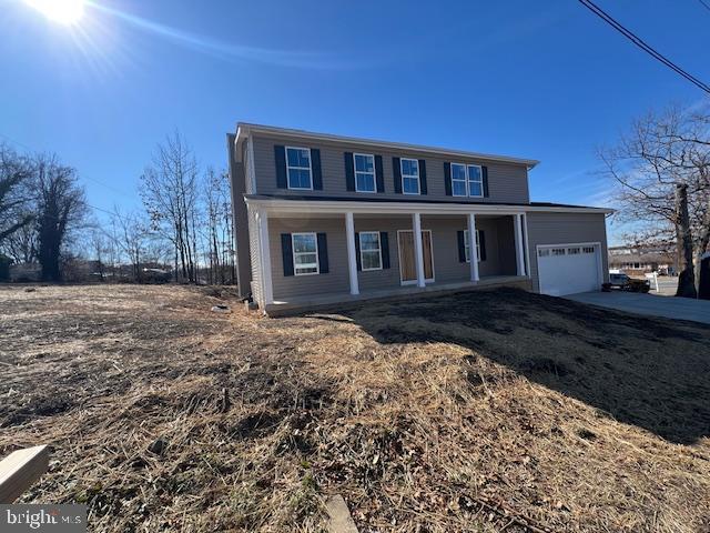 view of front facade featuring a garage, driveway, and covered porch