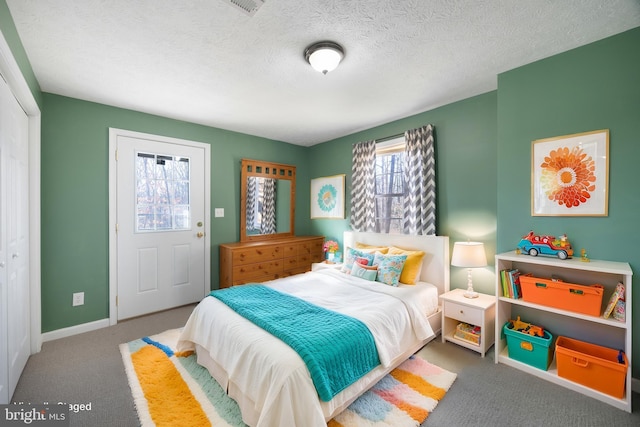 carpeted bedroom with baseboards and a textured ceiling