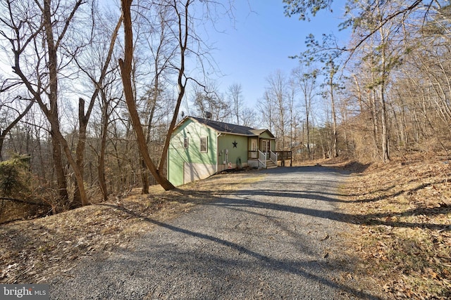 view of side of home with gravel driveway