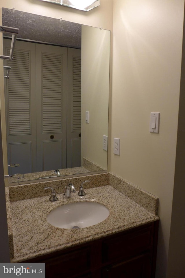 bathroom with a closet and vanity