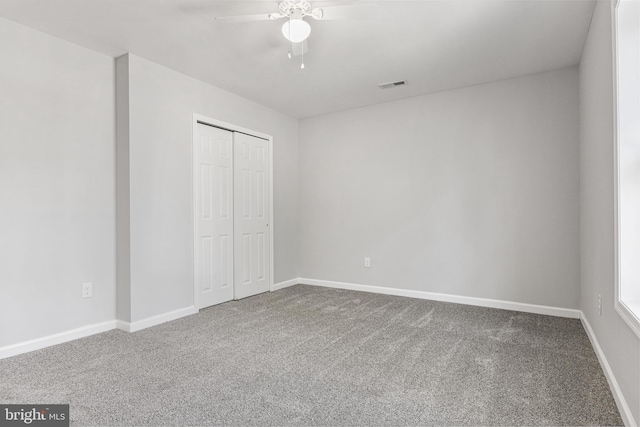 unfurnished bedroom with visible vents, baseboards, ceiling fan, carpet, and a closet