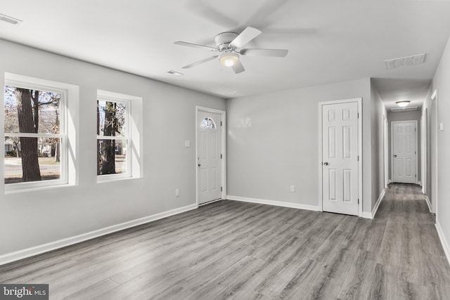 interior space with visible vents, baseboards, and wood finished floors