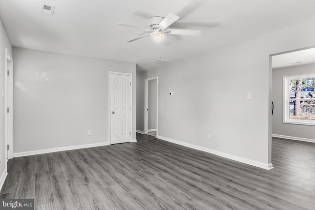 spare room featuring visible vents, ceiling fan, baseboards, and wood finished floors