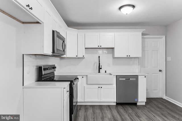 kitchen with light countertops, appliances with stainless steel finishes, a sink, and white cabinetry