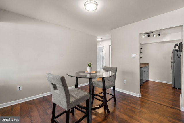 dining room featuring baseboards and dark wood finished floors