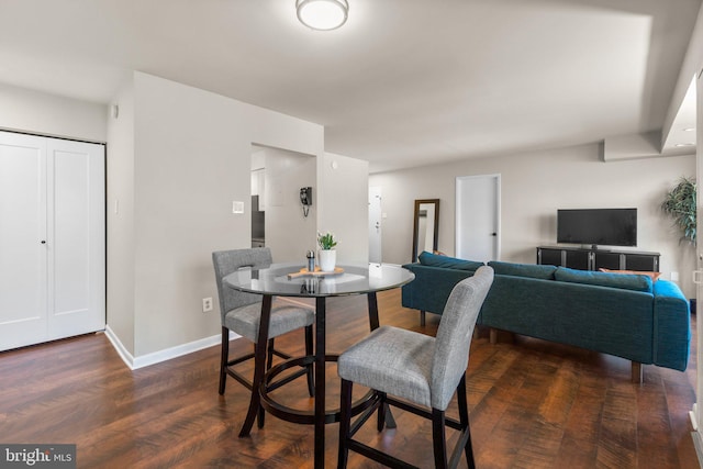 dining room featuring dark wood-style floors and baseboards