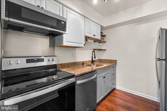 kitchen featuring baseboards, dark wood-style flooring, a sink, stainless steel appliances, and white cabinetry