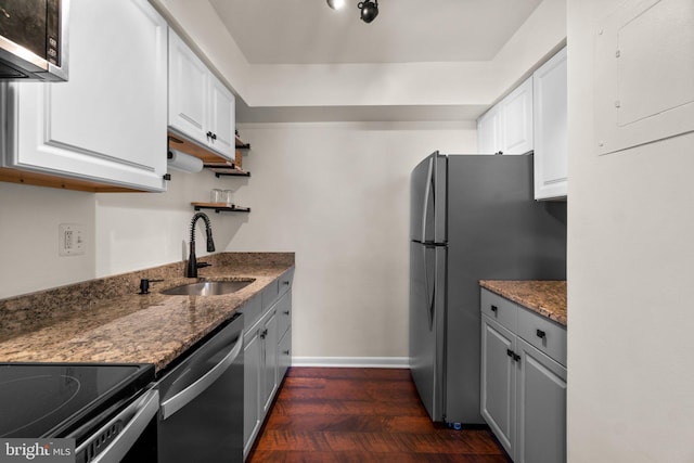 kitchen with a sink, electric panel, white cabinetry, and stainless steel appliances