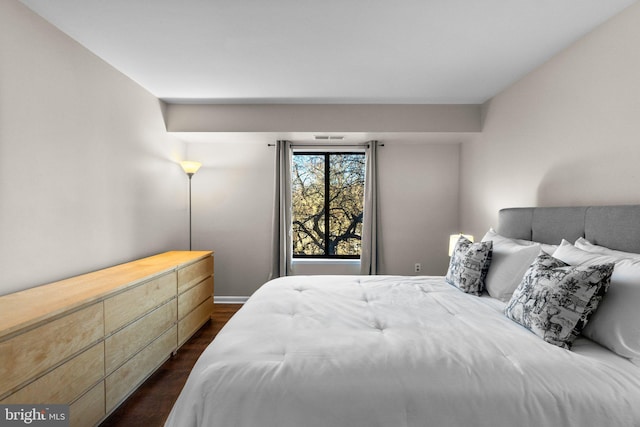 bedroom with dark wood finished floors