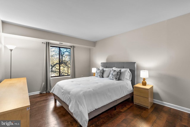 bedroom featuring dark wood-style floors and baseboards