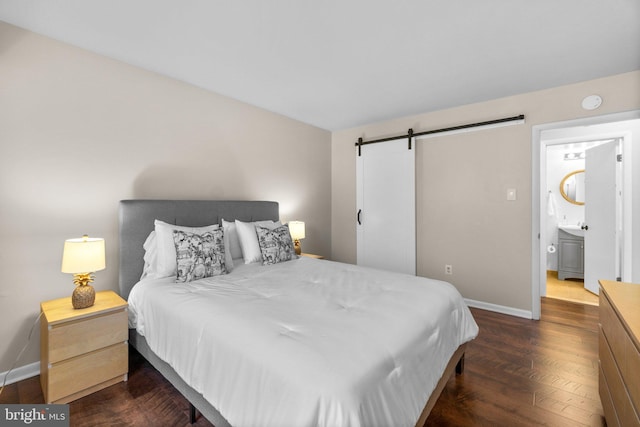 bedroom with a barn door, baseboards, and dark wood-style floors