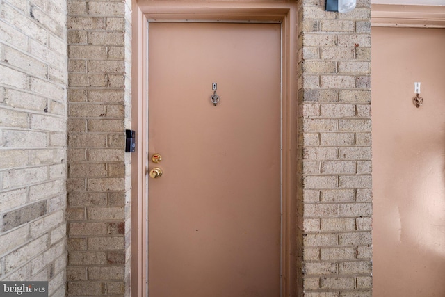 view of exterior entry featuring brick siding