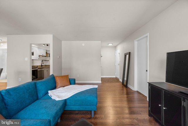 living area featuring baseboards and dark wood finished floors