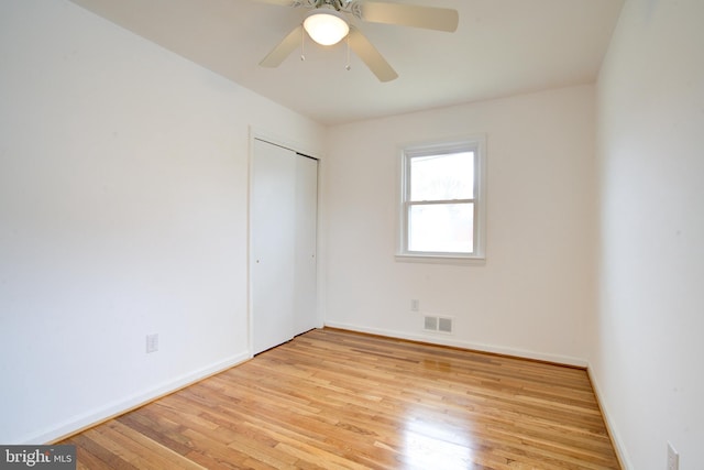 unfurnished bedroom with baseboards, visible vents, a closet, and light wood-type flooring